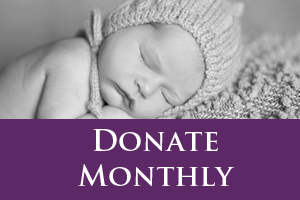 black and white photograph of sleeping baby with text underneath that reads donate monthly