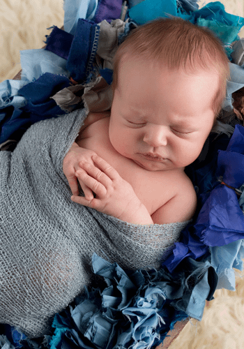 photograph of sleeping baby in blue blankets