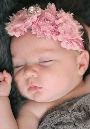 photograph of sleeping baby with pink flower hairband