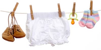 photograph of clothesline with shoes, diaper, pacifier and socks
